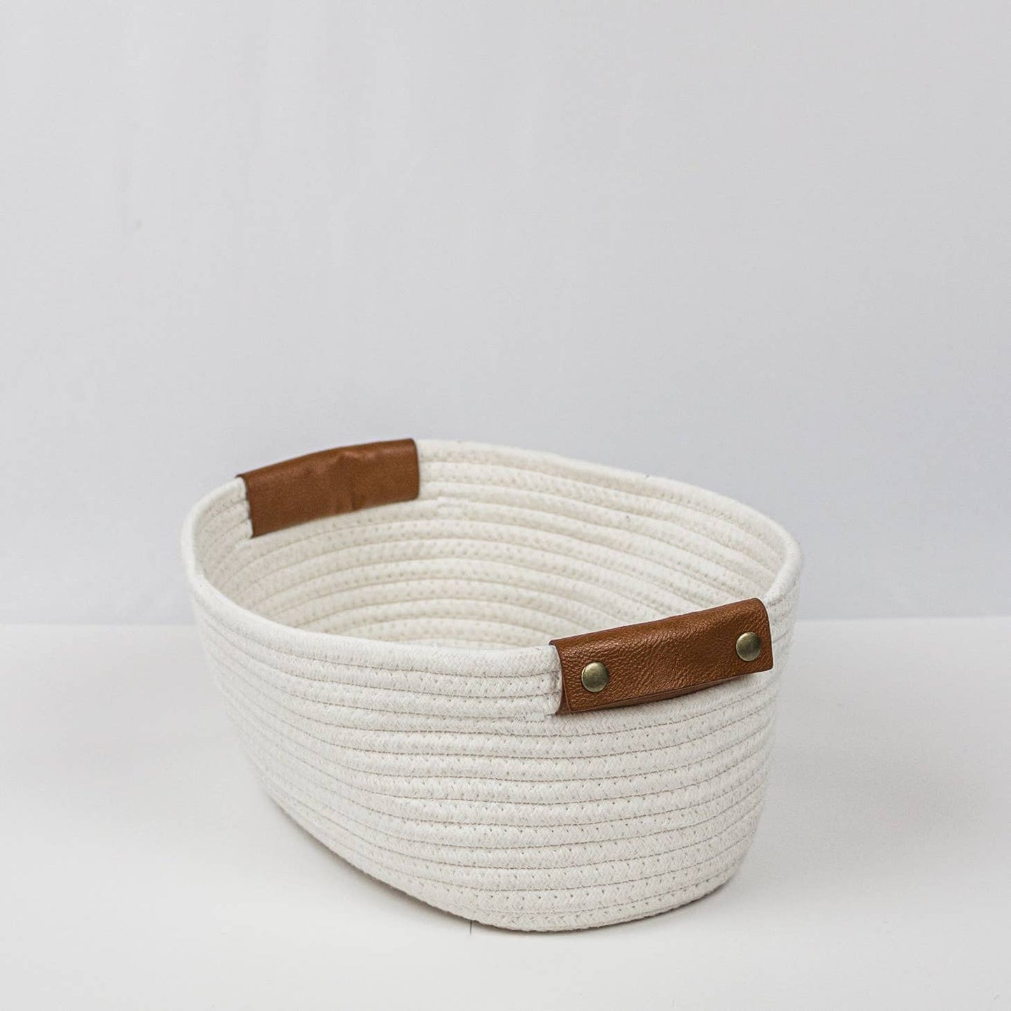 Woven storage basket with leather handles